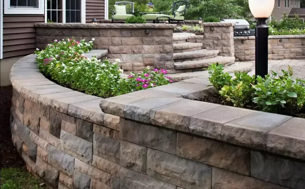 hardscape design in knoxville brick and concrete pavers with garden bed holding white and purple flowers