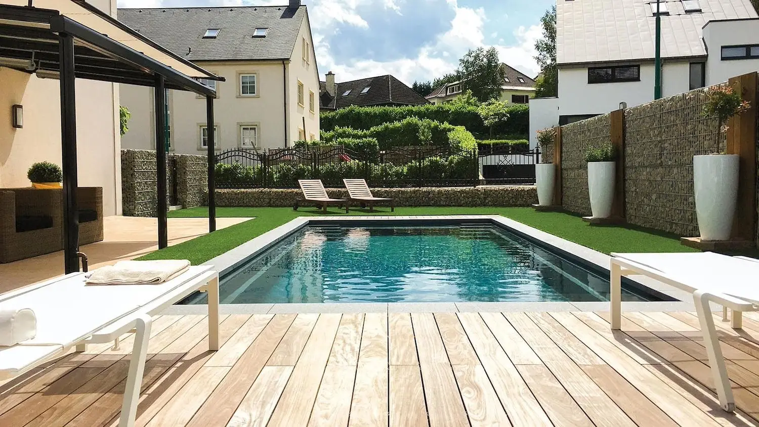 Imagine plunge pool volcanic black in knoxville with wood deck and green turf